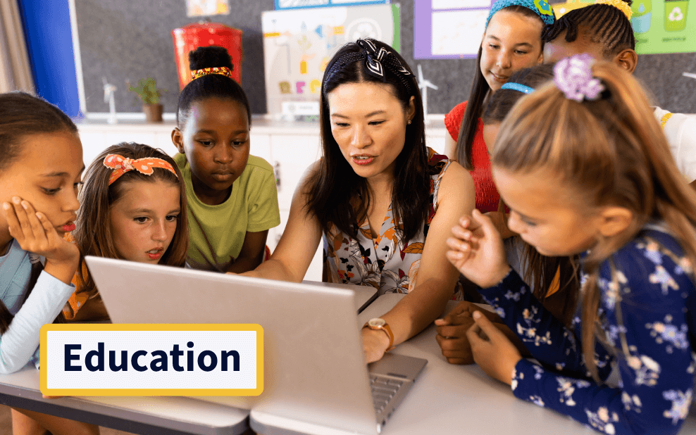 a teacher showing a laptop screen to her students