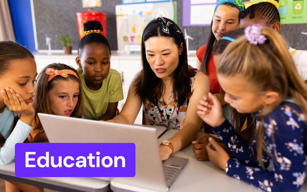 a teacher showing a laptop screen to her students